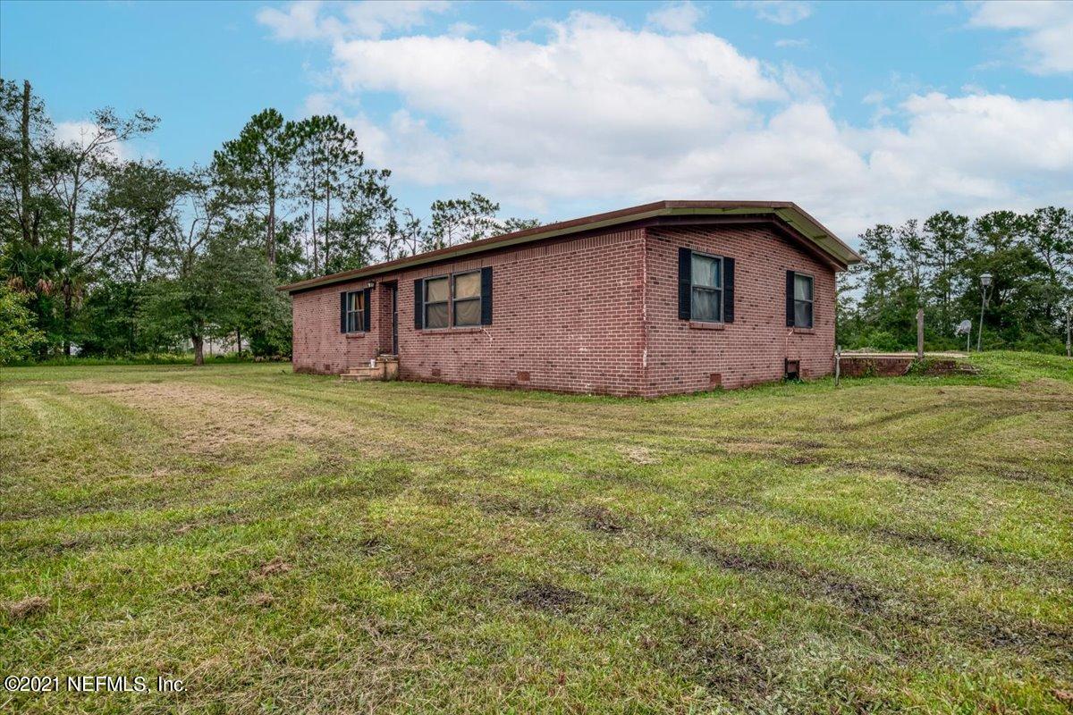 140 Keystone Road Palatka, FL 32177 - Photo 4 of 33 a white house that has a big yard with wooden fence