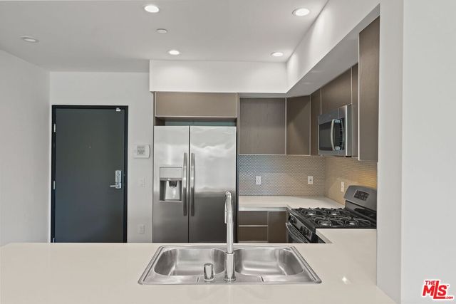 a kitchen with granite countertop a refrigerator and a sink
