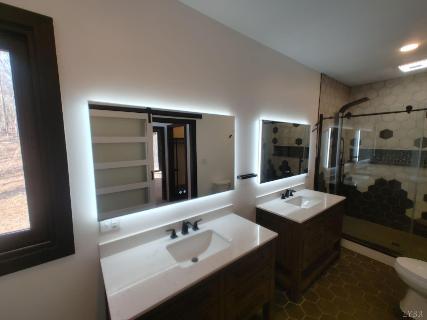 8915 Charlemont Road Goode, VA 24556 - Photo 62 of 96 a bathroom with a sink double vanity granite tub shower and a mirror