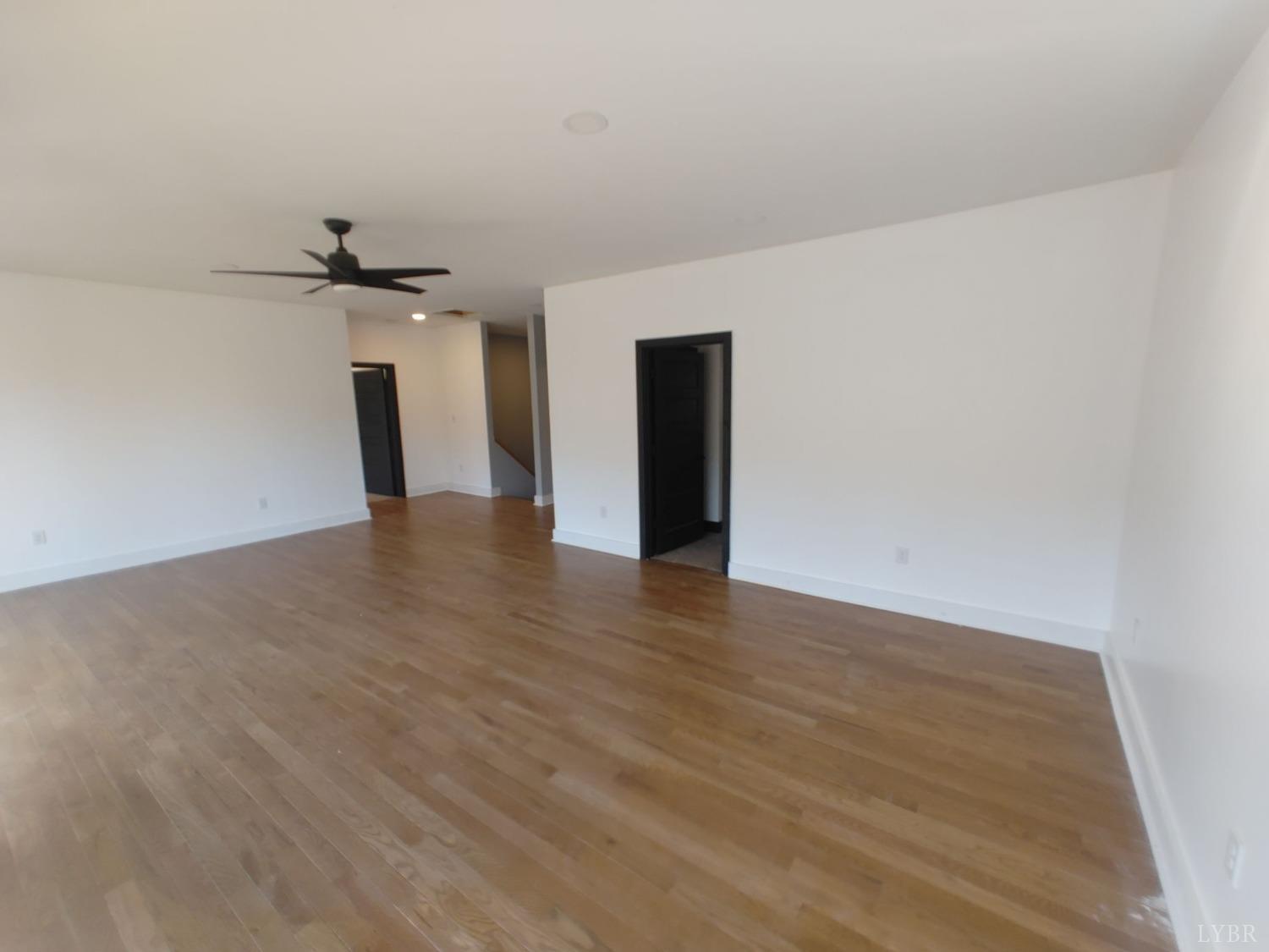 8915 Charlemont Road Goode, VA 24556 - Photo 66 of 96 a view of an empty room with a ceiling fan and wooden floor