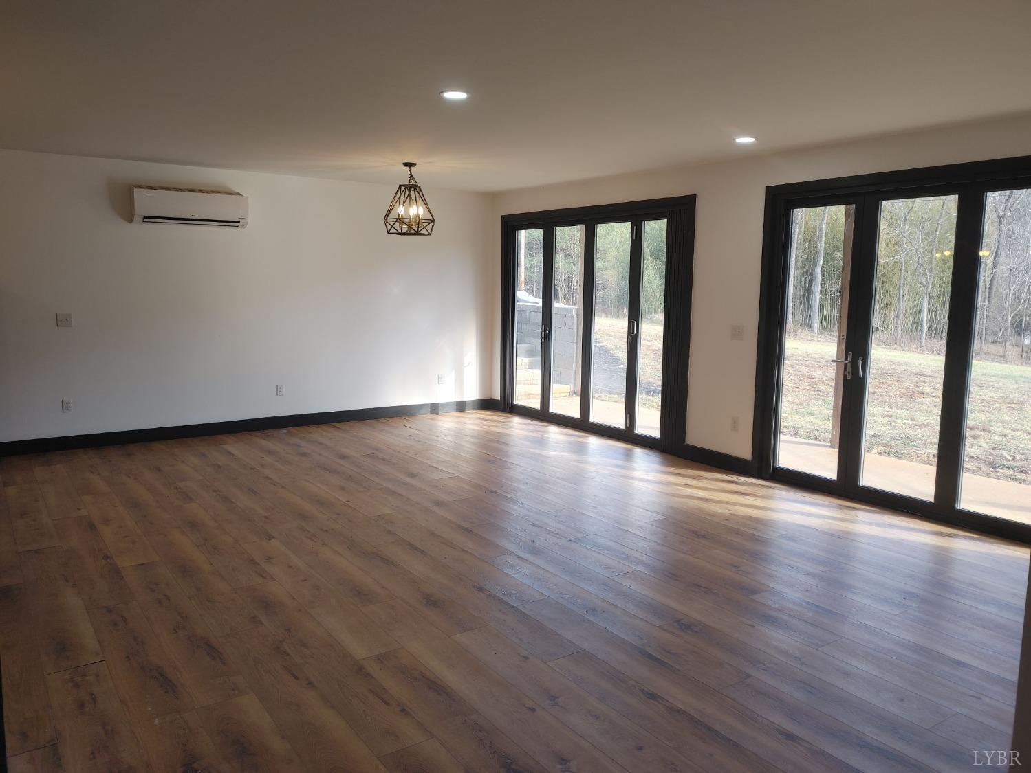8915 Charlemont Road Goode, VA 24556 - Photo 7 of 96 a view of an empty room with wooden floor and a window