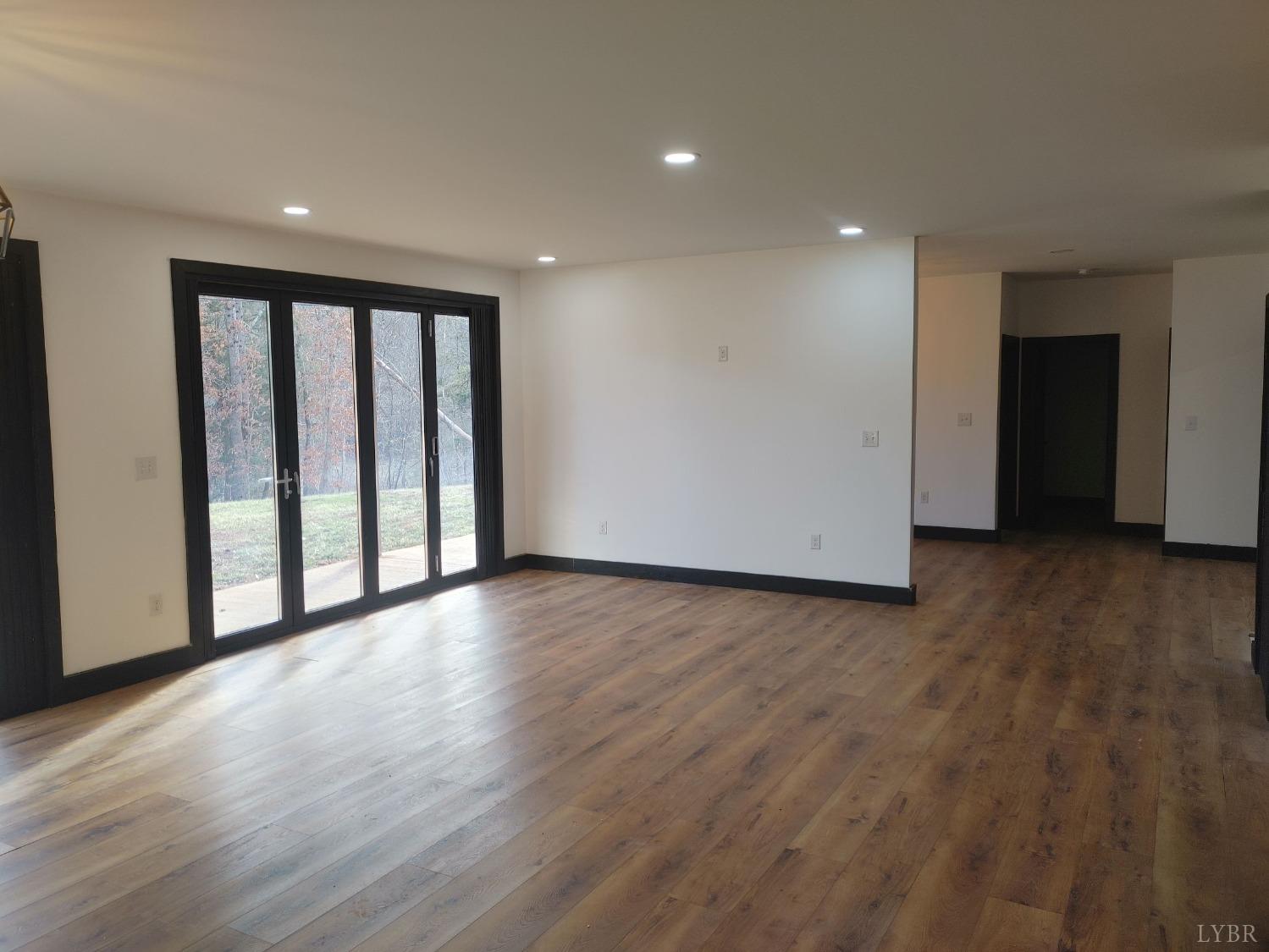 8915 Charlemont Road Goode, VA 24556 - Photo 8 of 96 a view of an empty room with wooden floor and a window