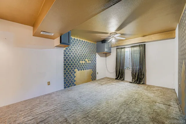 a view of a livingroom with a ceiling fan and window