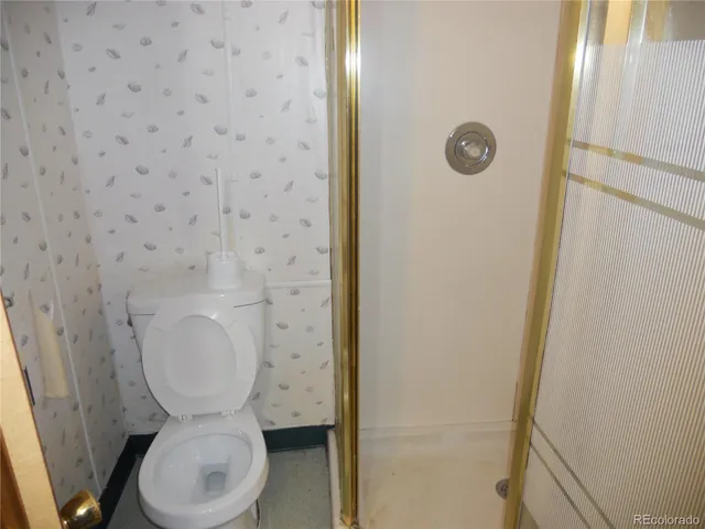 a white toilet sitting next to a shower in a bathroom