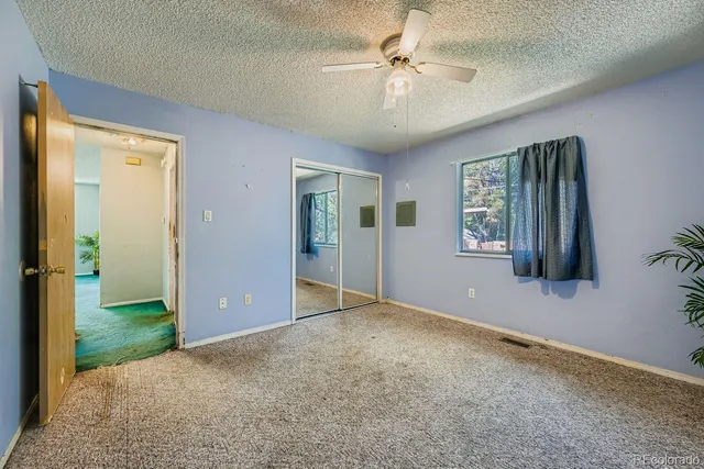an empty room with windows and ceiling fan