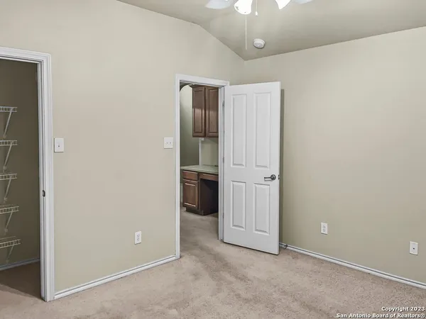 an empty room with closet and windows