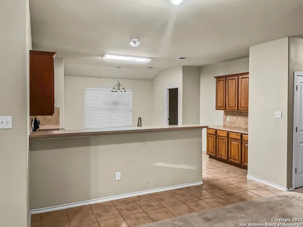 a view of a kitchen with a sink and dishwasher a refrigerator with wooden cabinets