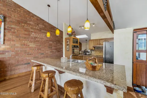 a kitchen with stainless steel appliances granite countertop a sink a counter space and cabinets