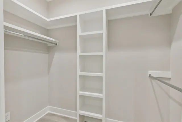 a view of walk in closet with empty racks