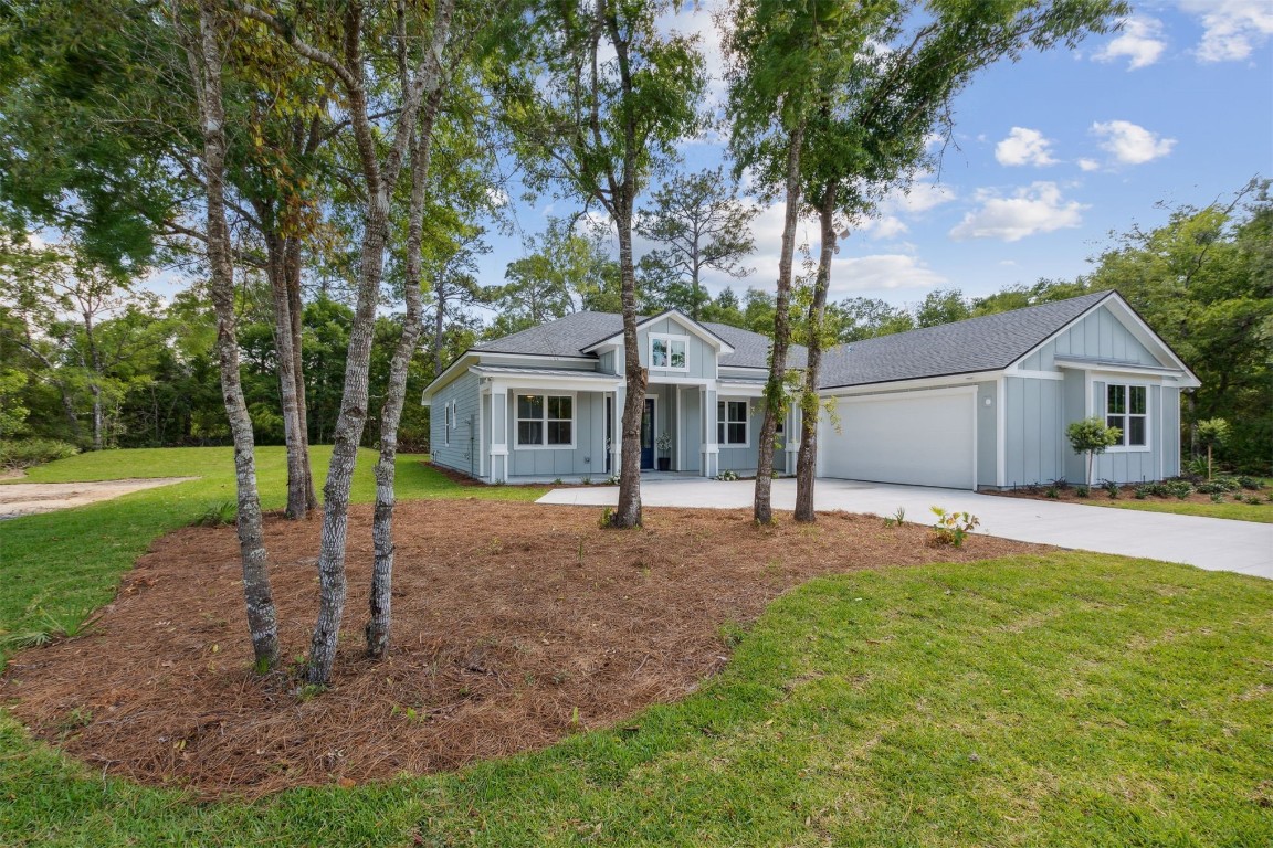 96050 Captains Pointe Road Yulee, FL 32097 - Photo 2 of 37 a front view of a house with a garden and trees
