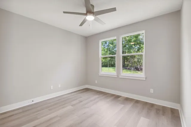 a view of a livingroom with a ceiling fan and windows