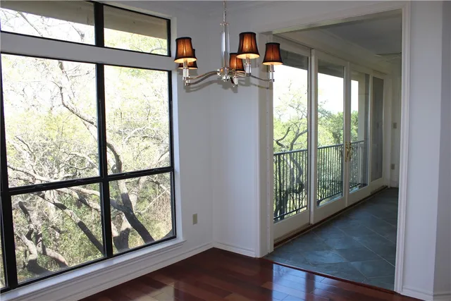 an empty room with wooden floor and potted plant