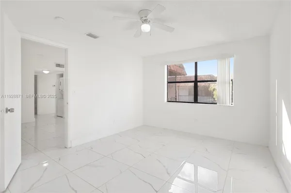 an empty room with windows and cabinet