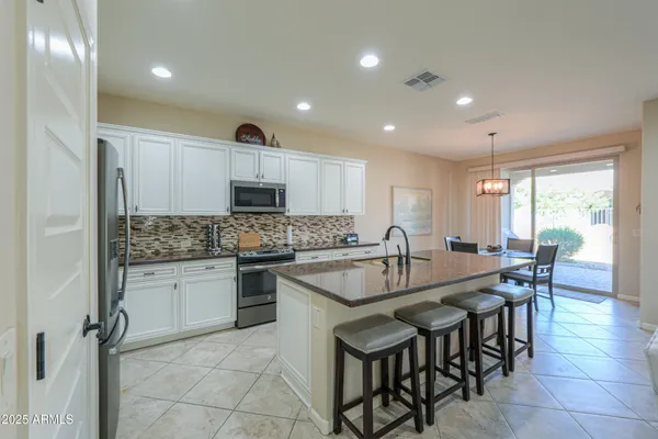 a kitchen with granite countertop white cabinets and stainless steel appliances