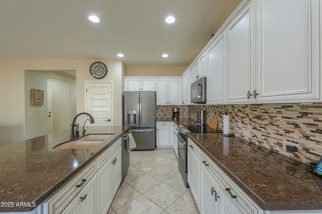a kitchen with granite countertop a sink stainless steel appliances and cabinets