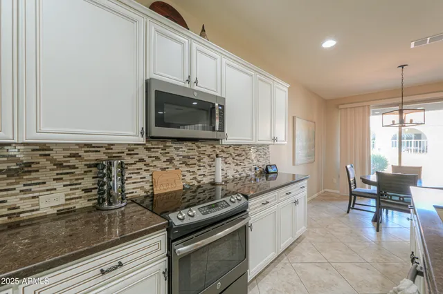 a large kitchen with a table and chairs