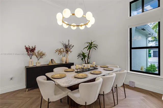 a view of a dining room with furniture a chandelier and wooden floor