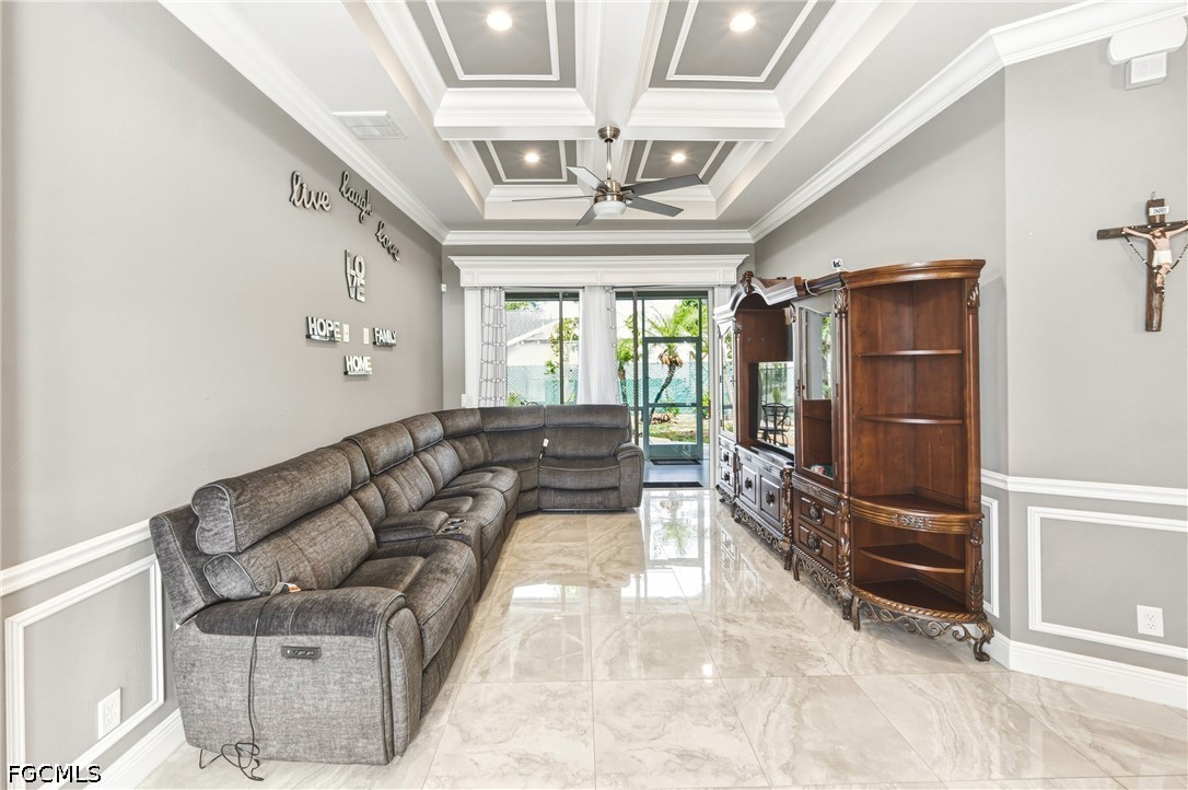 1700 43rd Terrace Southwest Naples, FL 34116 - Photo 12 of 38 a living room with furniture a chandelier and a flat screen tv
