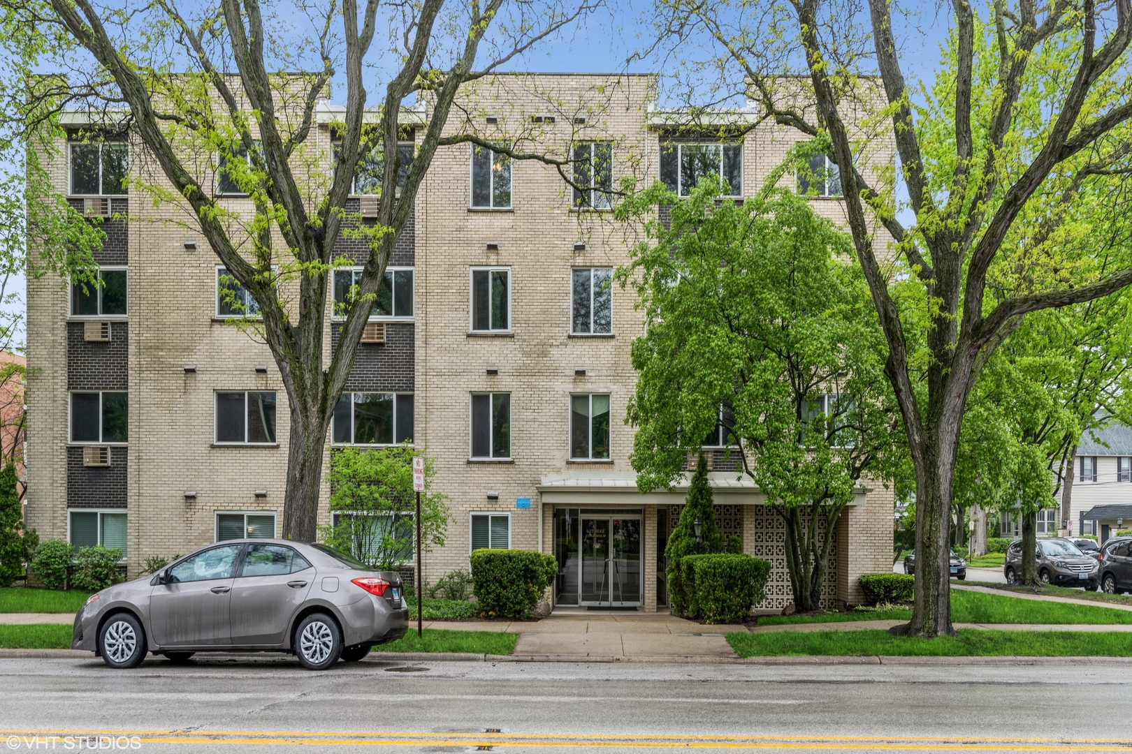 627 Ridge Road, Unit 401 Wilmette, IL 60091 - Photo 1 of 12 a white house that has a tree in front of it