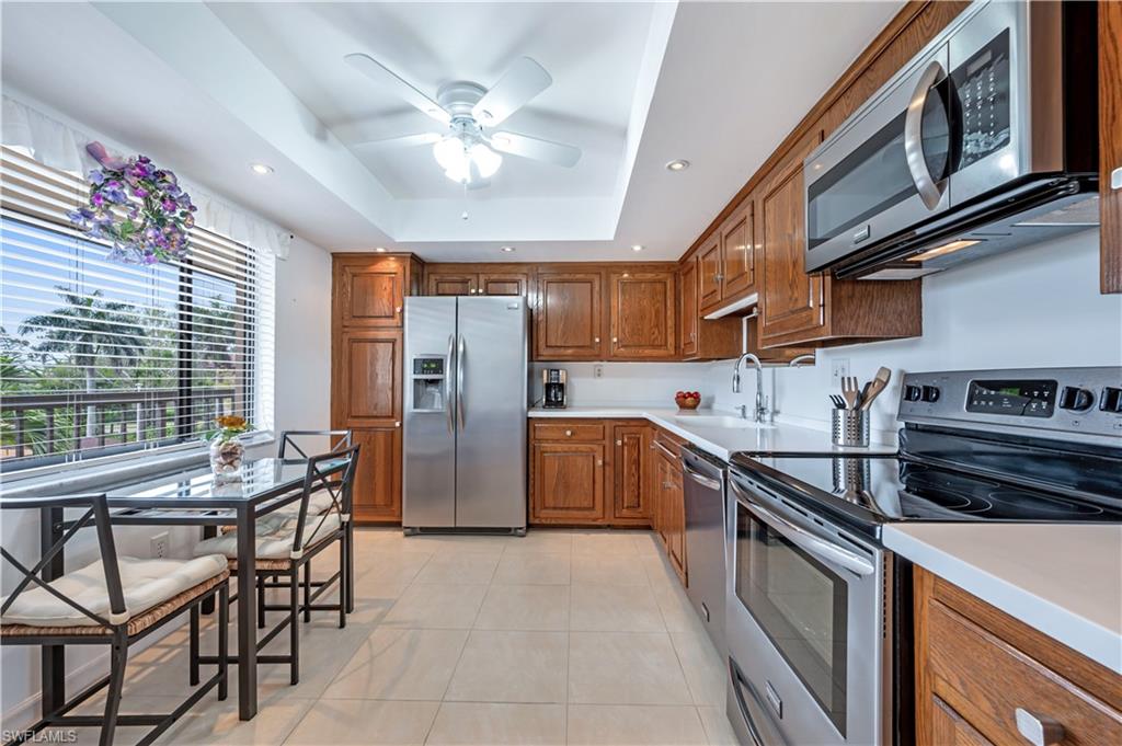 415 Augusta Boulevard, Unit 307 Naples, FL 34113 - Photo 12 of 36 a kitchen with stainless steel appliances granite countertop a sink a stove a refrigerator cabinets and dining table