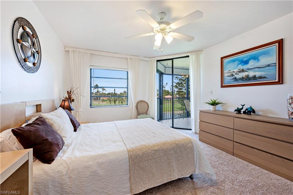 415 Augusta Boulevard, Unit 307 Naples, FL 34113 - Photo 16 of 36 a bedroom with a bed and a large window