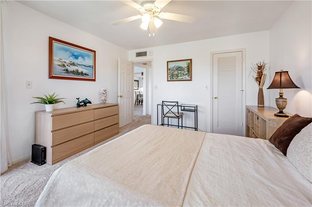 415 Augusta Boulevard, Unit 307 Naples, FL 34113 - Photo 17 of 36 a bedroom with a bed and a chandelier