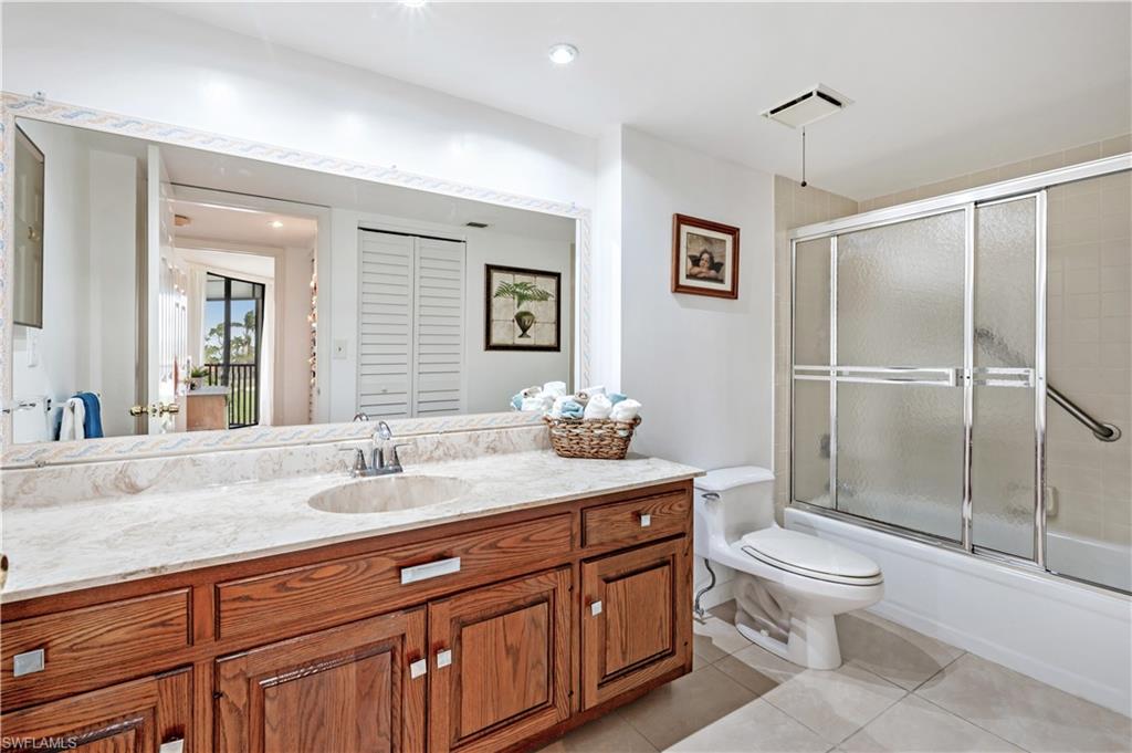 415 Augusta Boulevard, Unit 307 Naples, FL 34113 - Photo 18 of 36 a spacious bathroom with a granite countertop sink toilet a mirror and shower