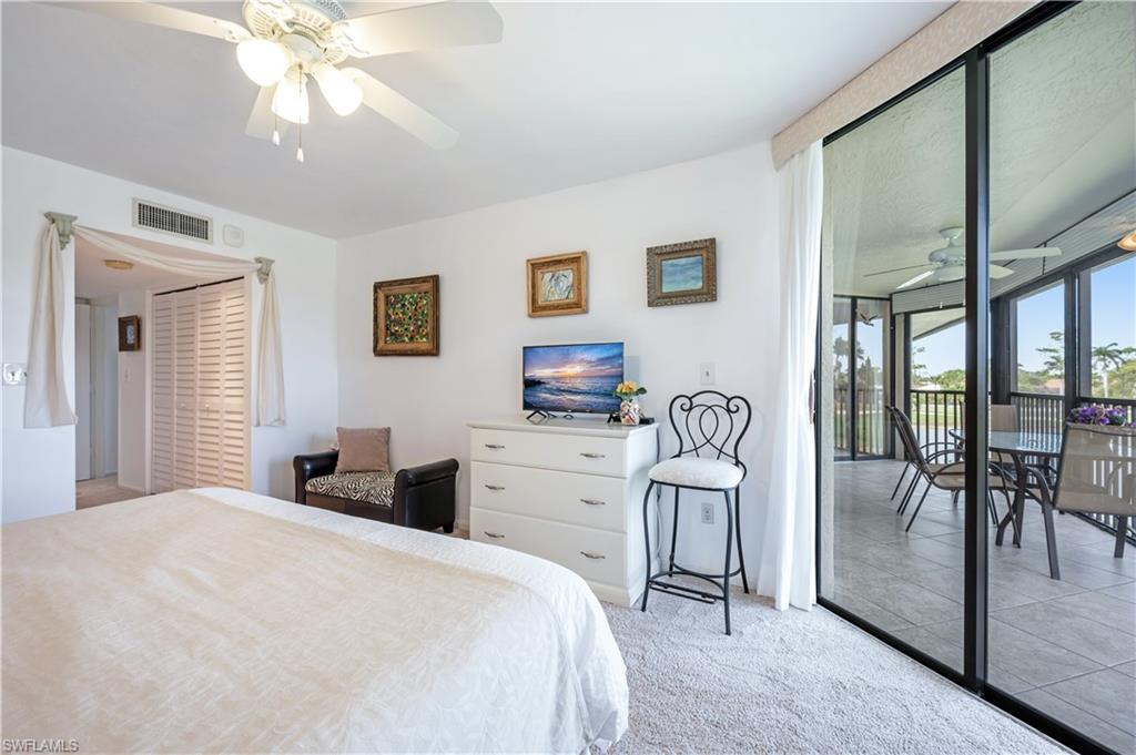 415 Augusta Boulevard, Unit 307 Naples, FL 34113 - Photo 22 of 36 a bedroom with a bed and a chandelier