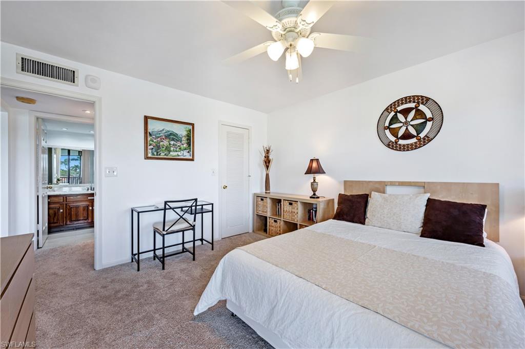 415 Augusta Boulevard, Unit 307 Naples, FL 34113 - Photo 24 of 36 a bedroom with a bed and a chandelier