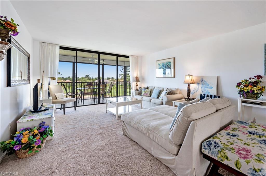 415 Augusta Boulevard, Unit 307 Naples, FL 34113 - Photo 3 of 36 a living room with furniture and a floor to ceiling window