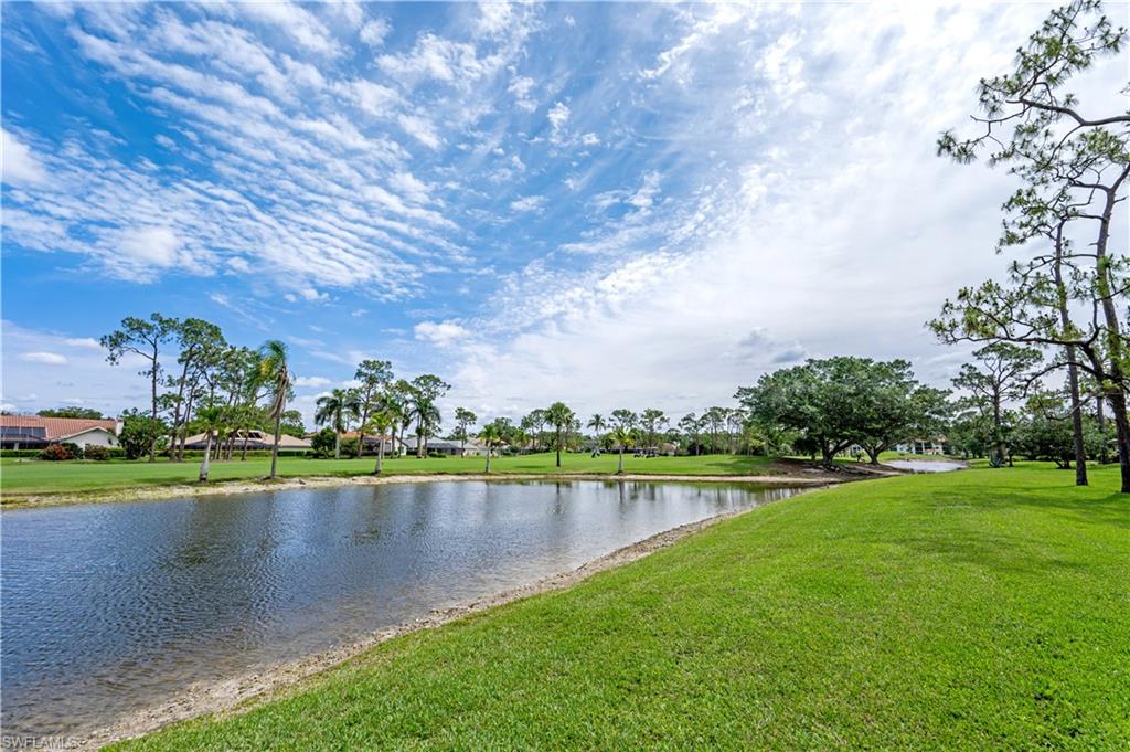 415 Augusta Boulevard, Unit 307 Naples, FL 34113 - Photo 32 of 36 a view of a lake with houses in the back