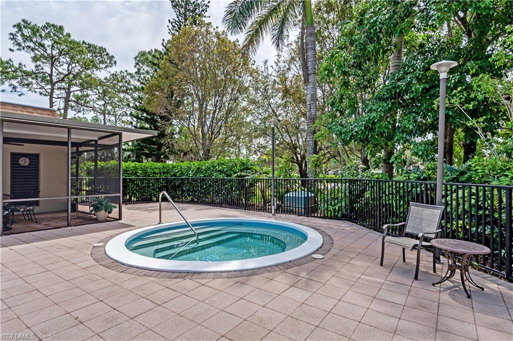 415 Augusta Boulevard, Unit 307 Naples, FL 34113 - Photo 34 of 36 a view of a swimming pool with a table and chairs