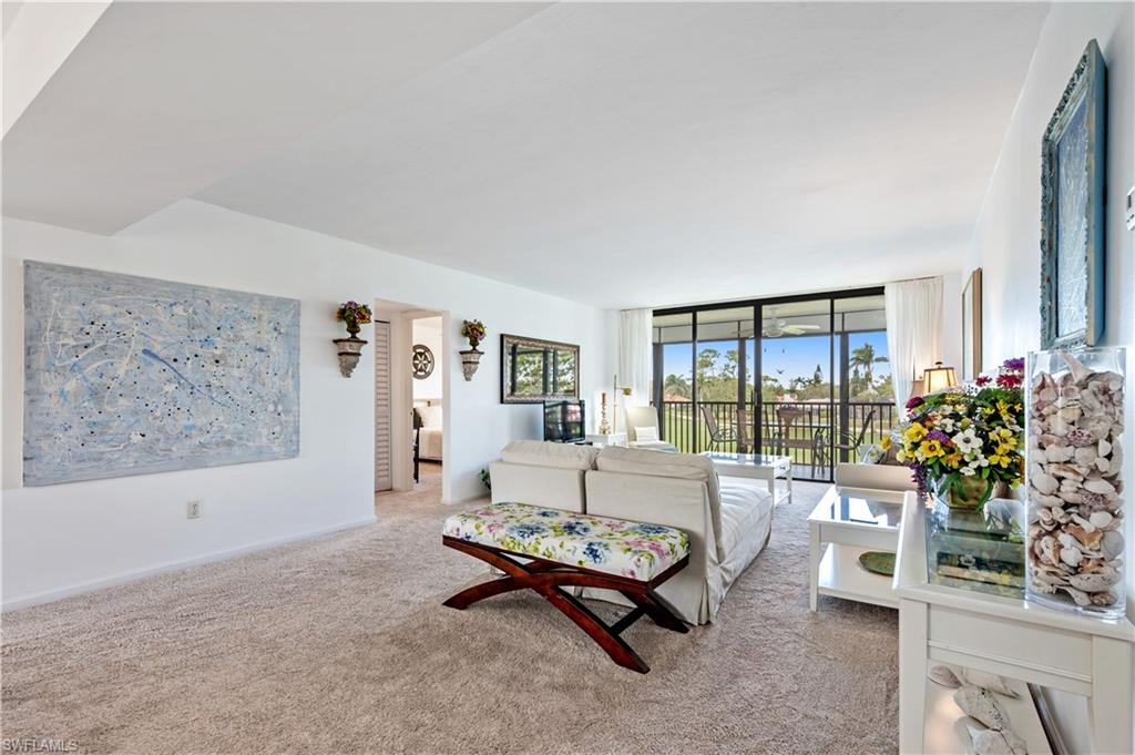 415 Augusta Boulevard, Unit 307 Naples, FL 34113 - Photo 4 of 36 a living room with furniture and a potted plant