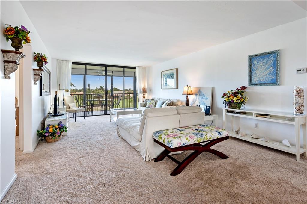 415 Augusta Boulevard, Unit 307 Naples, FL 34113 - Photo 5 of 36 a living room with furniture and a table