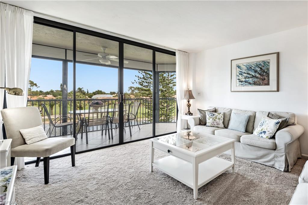 415 Augusta Boulevard, Unit 307 Naples, FL 34113 - Photo 6 of 36 a living room with furniture and a large window