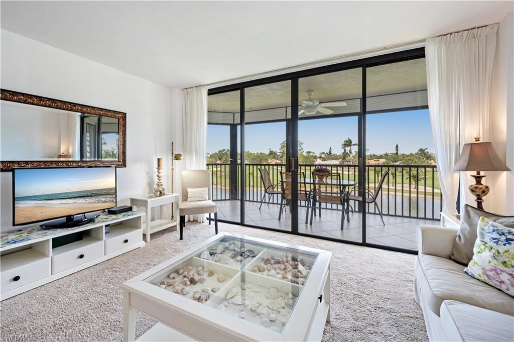 415 Augusta Boulevard, Unit 307 Naples, FL 34113 - Photo 7 of 36 a living room with furniture tv and a window