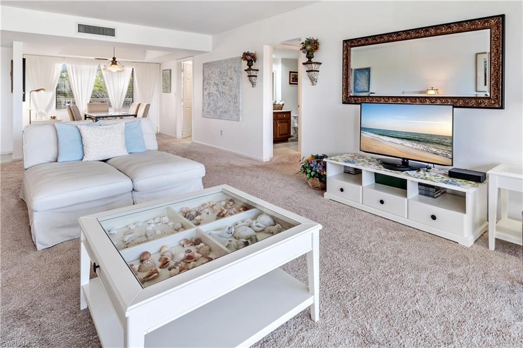 415 Augusta Boulevard, Unit 307 Naples, FL 34113 - Photo 8 of 36 a living room with furniture and a flat screen tv