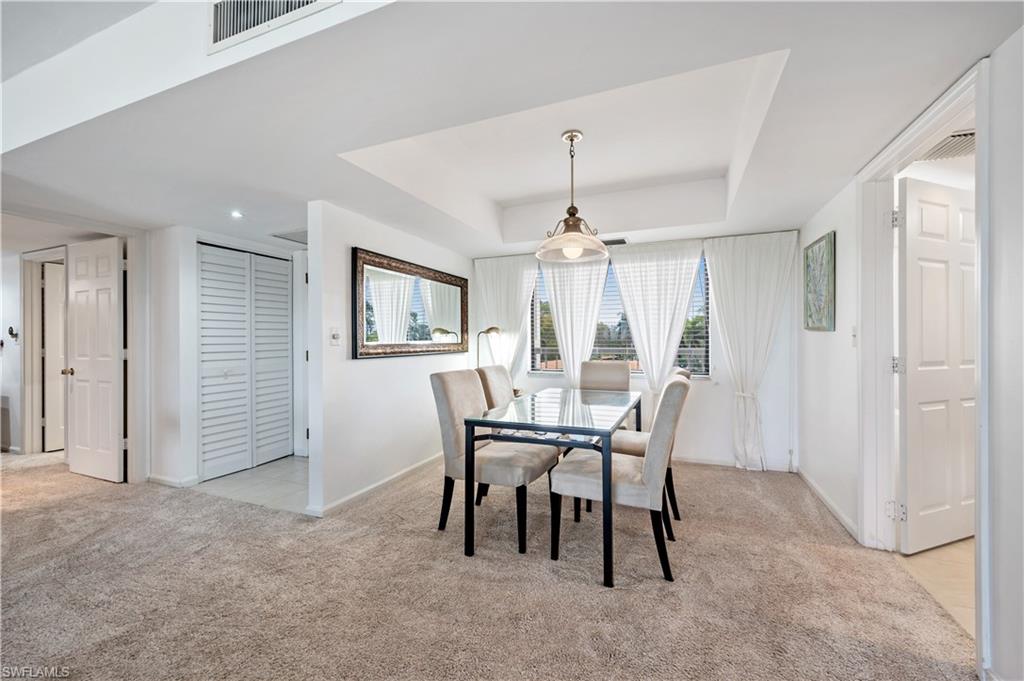 415 Augusta Boulevard, Unit 307 Naples, FL 34113 - Photo 10 of 36 a view of a dining room with furniture and chandelier