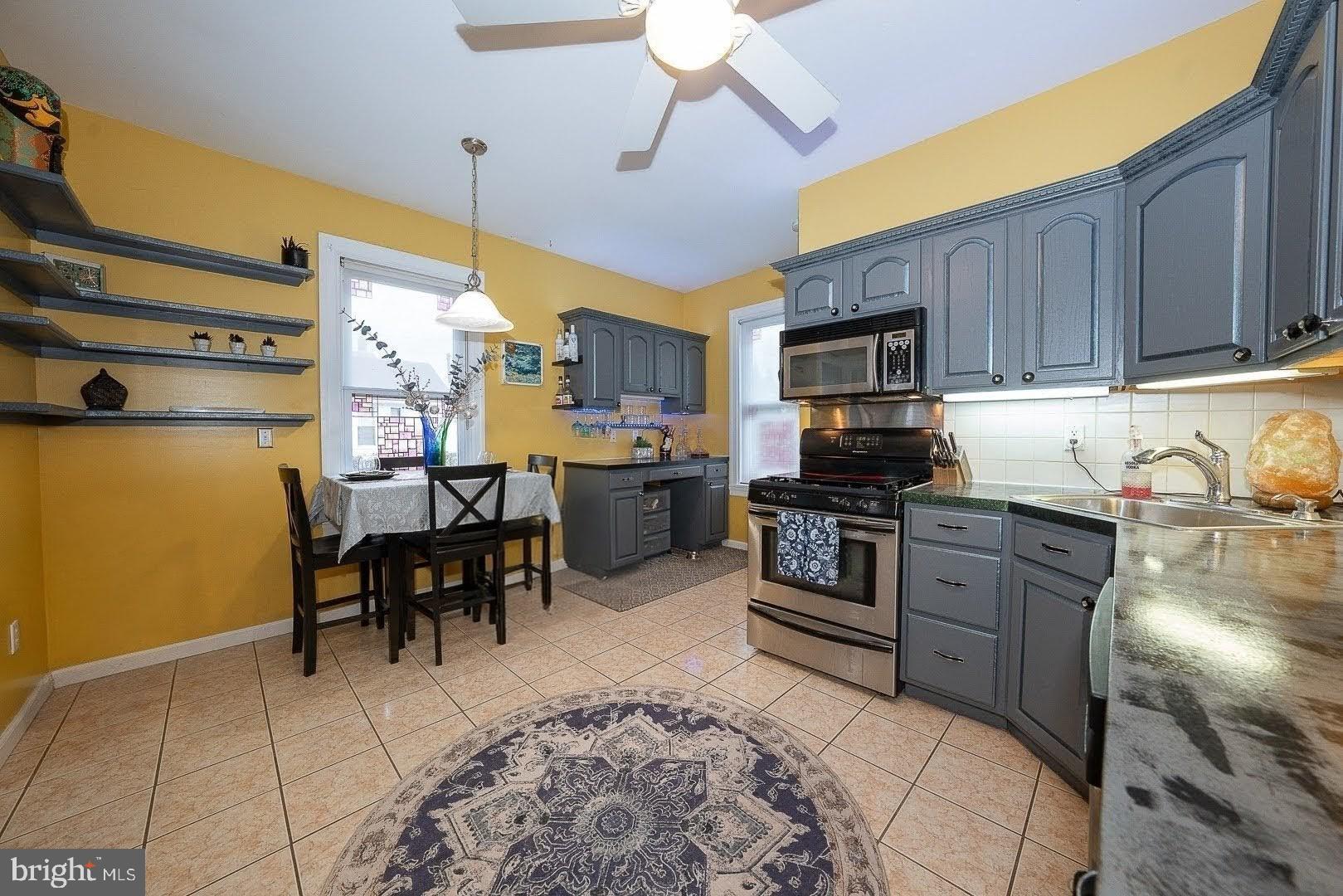 507 Morton Avenue Ridley Park, PA 19078 - Photo 18 of 42 a kitchen with stainless steel appliances granite countertop a stove top oven a sink a dining table and chairs with wooden floor