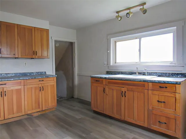 a kitchen with granite countertop wooden cabinets a sink and a window