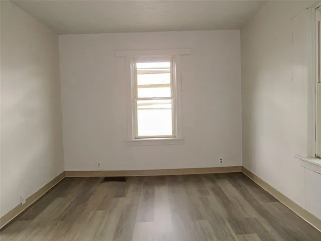a view of a room with wooden floor and window