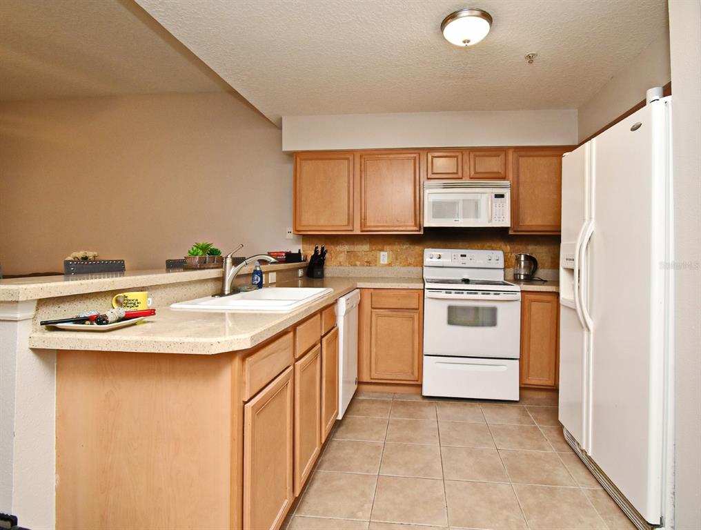 700 Seabrook Court, Unit 102 Altamonte Springs, FL 32714 - Photo 6 of 22 a kitchen with white cabinets sink and white appliances