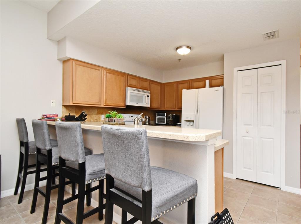 700 Seabrook Court, Unit 102 Altamonte Springs, FL 32714 - Photo 8 of 22 a kitchen with a table chairs refrigerator and cabinets