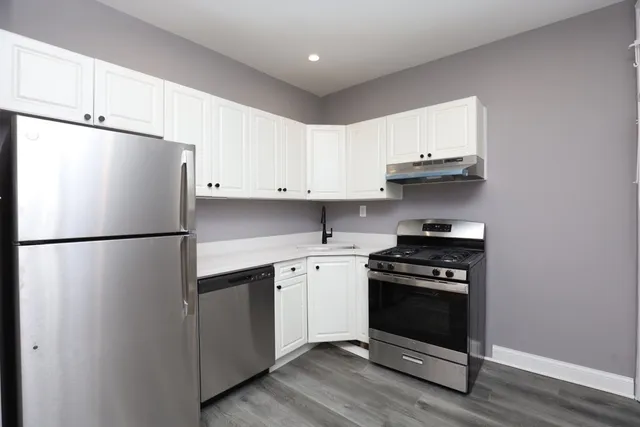 a kitchen with stainless steel appliances a refrigerator a stove a sink and cabinets