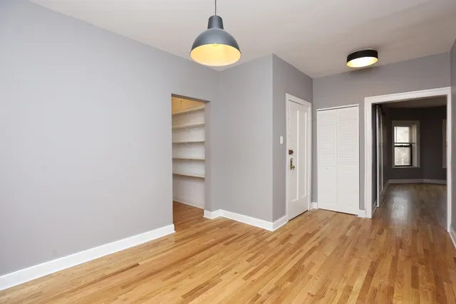 a view of a room with wooden floor and window