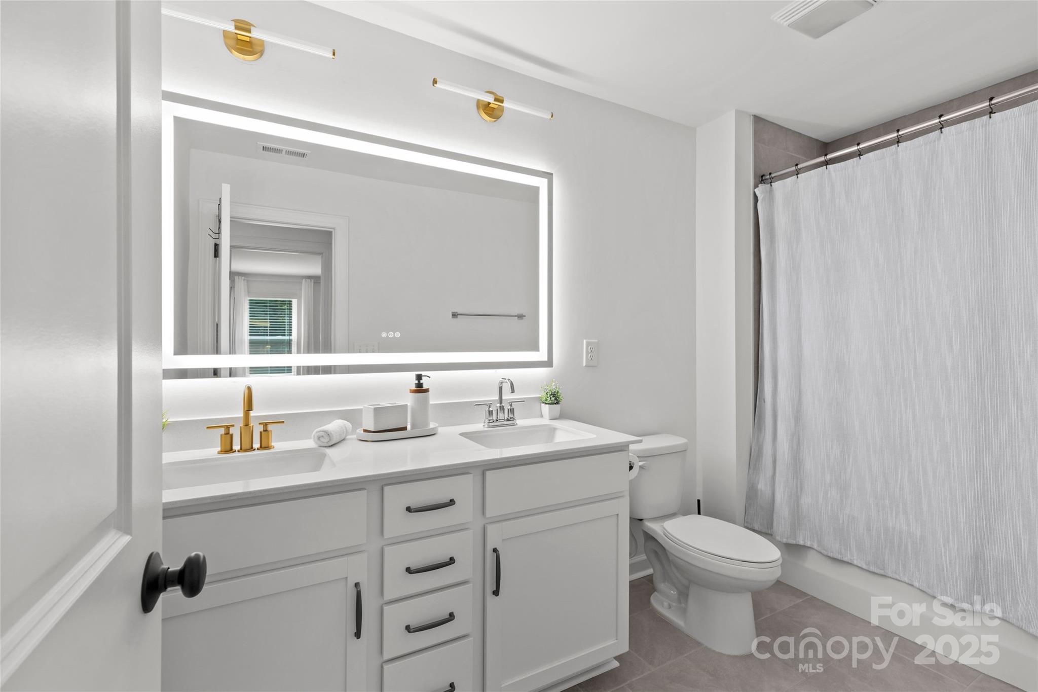 5902 Beatties Ford Road Charlotte, NC 28216 - Photo 37 of 48 a bathroom with a toilet a sink a vanity and mirror