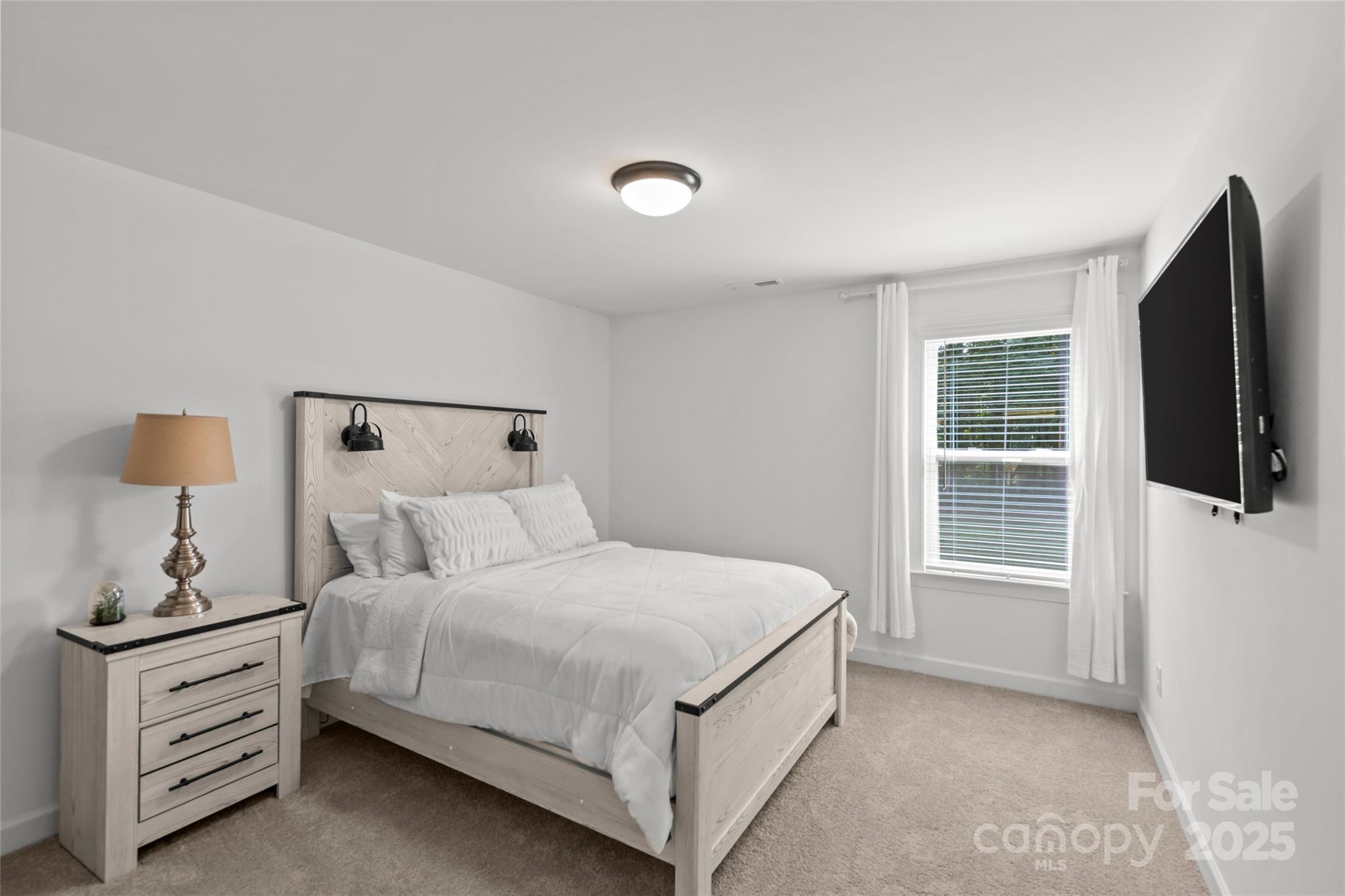 5902 Beatties Ford Road Charlotte, NC 28216 - Photo 39 of 48 a bedroom with a bed and a flat tv screen on a dresser