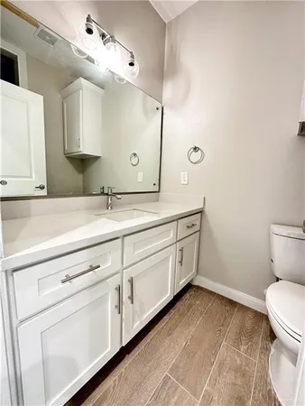 a spacious bathroom with a toilet sink and mirror