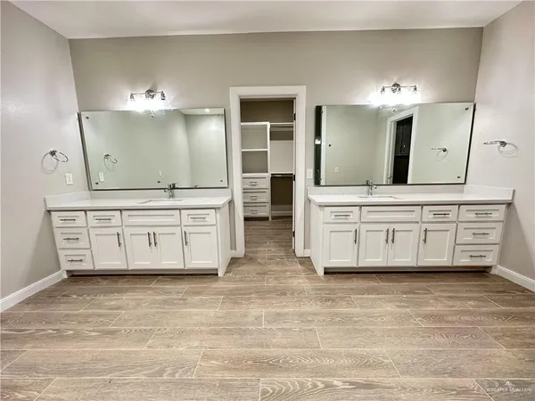 a spacious bathroom with a double vanity sink a mirror and a bathtub