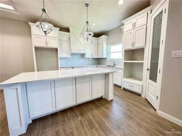 a kitchen with a refrigerator sink and cabinets